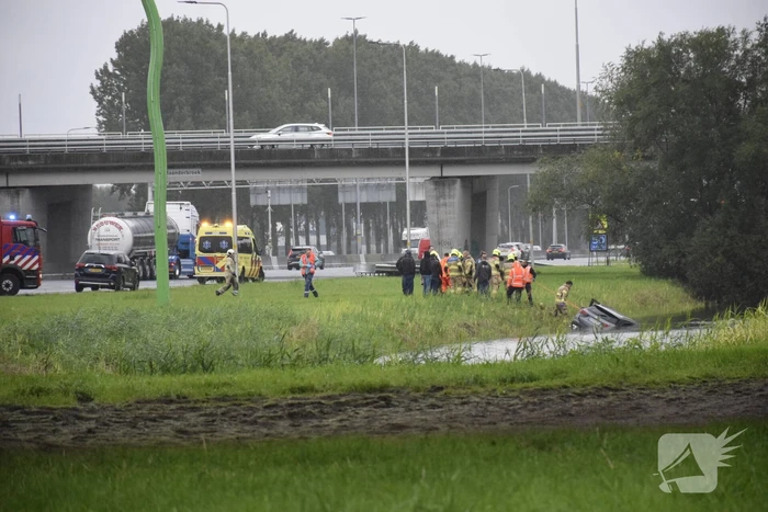 Auto raakt te water naast snelweg