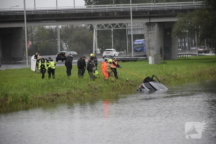 Auto raakt te water naast snelweg