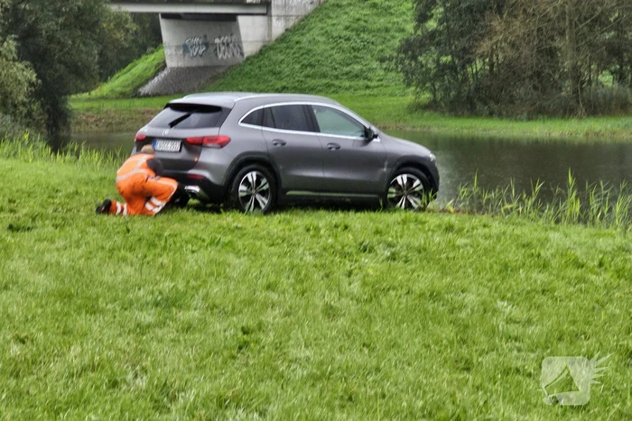 Auto raakt te water naast snelweg