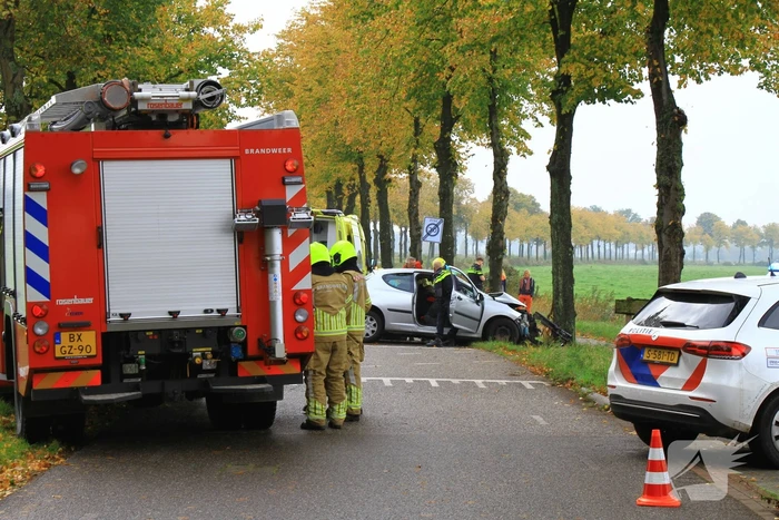 Bestuurder bekneld bij botsing tegen boom