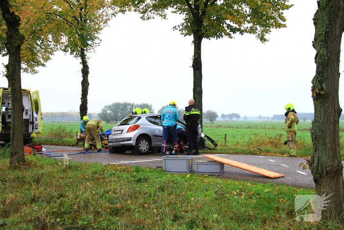 Bestuurder bekneld bij botsing tegen boom