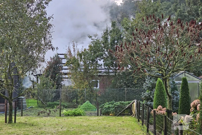 Grote brand in loods dreigt over te slaan naar woning