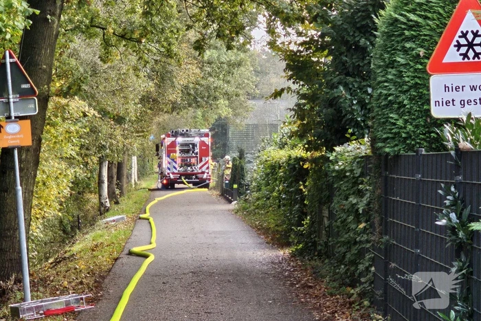 Grote brand in loods dreigt over te slaan naar woning
