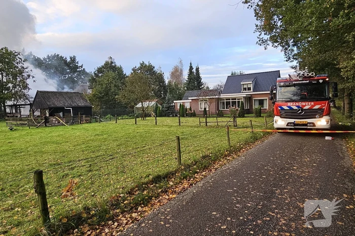 Grote brand in loods dreigt over te slaan naar woning