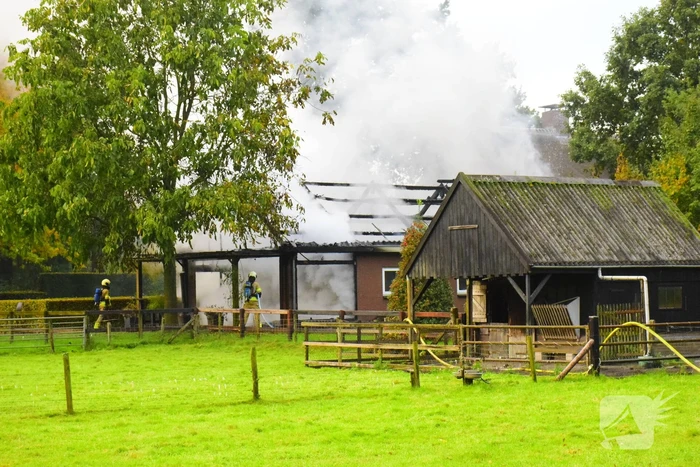 Grote brand in loods dreigt over te slaan naar woning