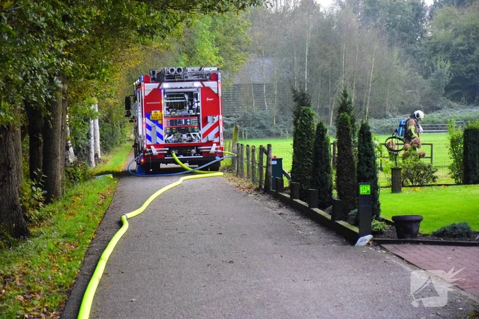 Grote brand in loods dreigt over te slaan naar woning