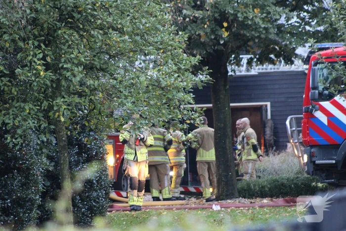 Grote brand in loods dreigt over te slaan naar woning