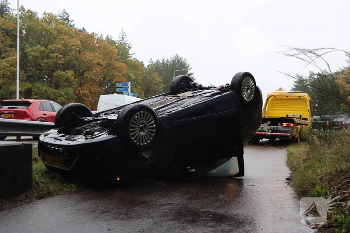 Auto vliegt over vangrail en belandt op kop