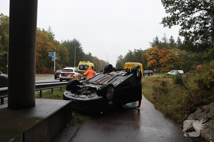 Auto vliegt over vangrail en belandt op kop