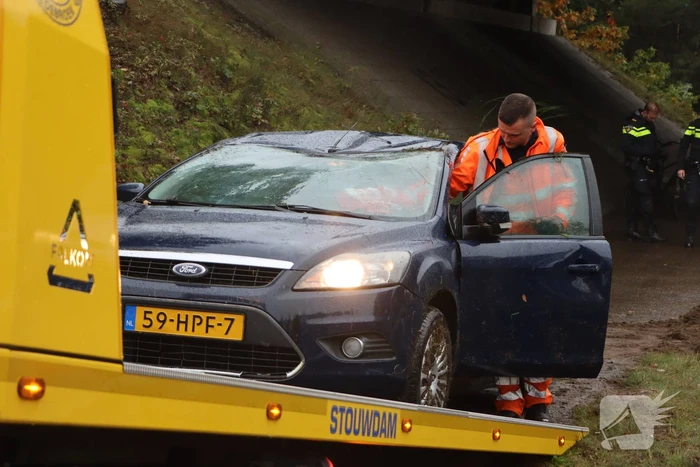 Auto vliegt over vangrail en belandt op kop