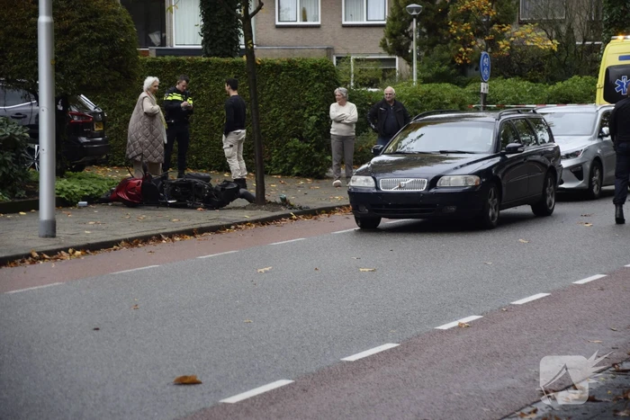 Overstekende scooter geschept door auto