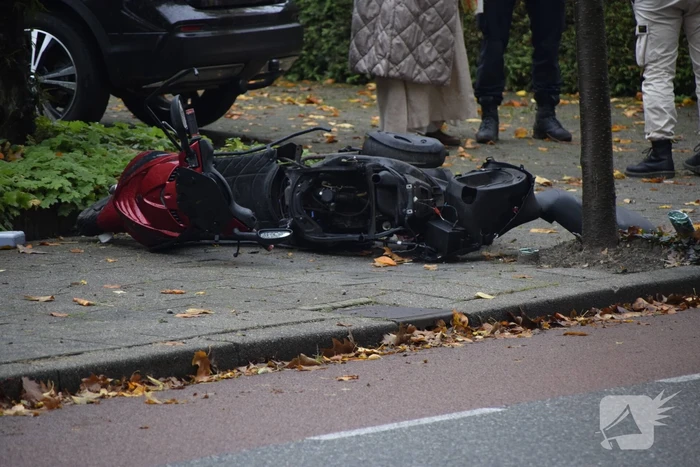 Overstekende scooter geschept door auto