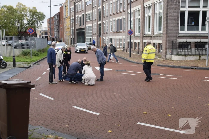 Persoon op scooter onderuit op kruising