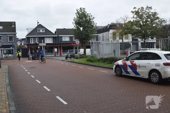 Persoon op scooter onderuit op kruising