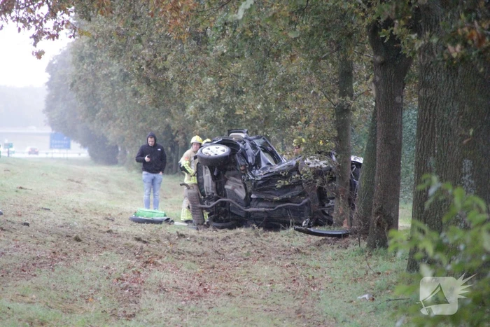 Auto zwaar beschadigd na botsing tegen boom langs snelweg