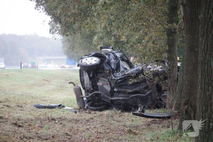 Auto zwaar beschadigd na botsing tegen boom langs snelweg