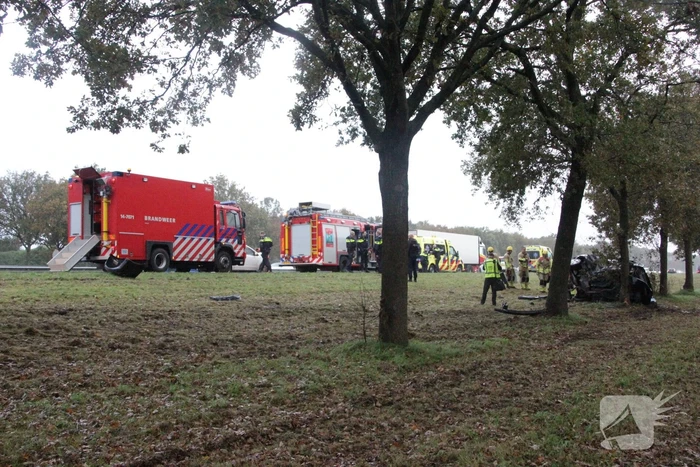 Auto zwaar beschadigd na botsing tegen boom langs snelweg