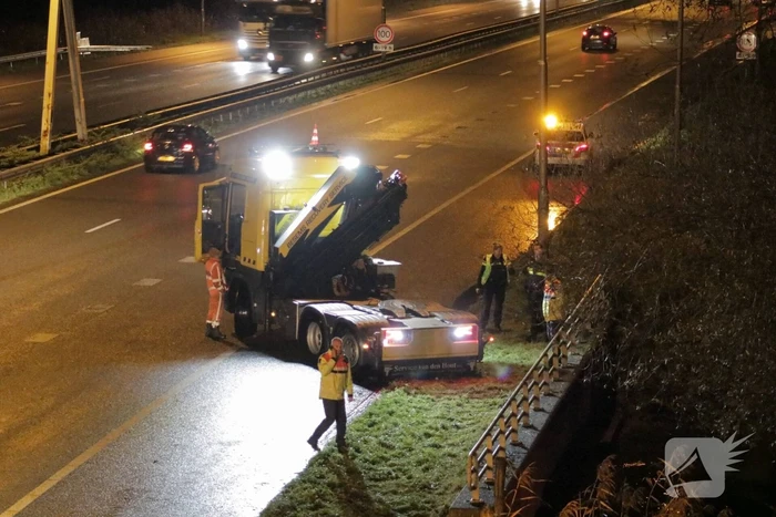 Auto belandt in water naast snelweg