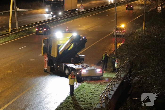 Auto belandt in water naast snelweg