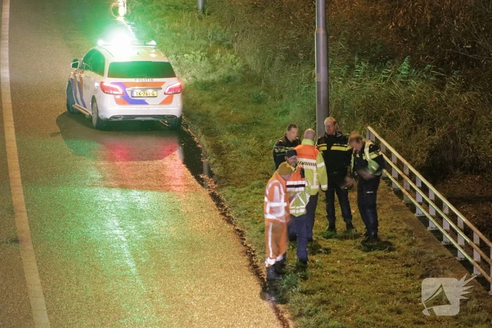 Auto belandt in water naast snelweg