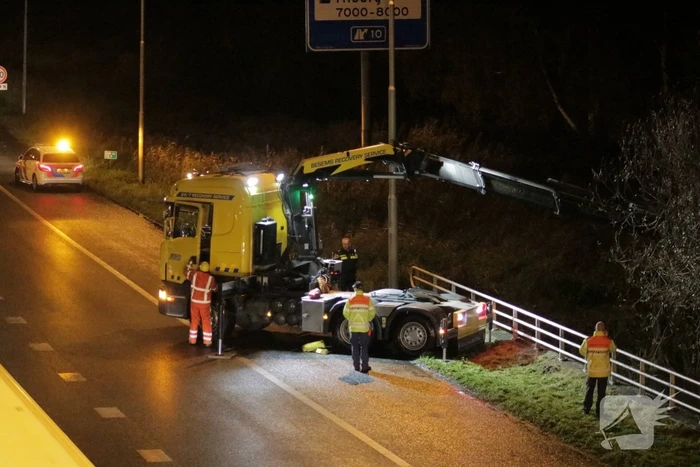 Auto belandt in water naast snelweg