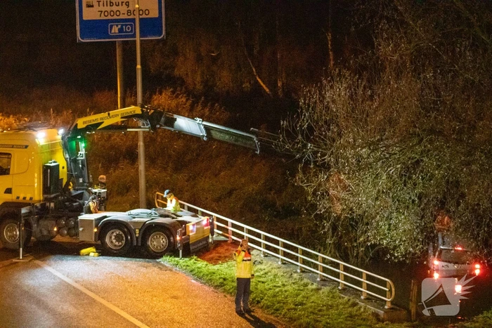 Auto belandt in water naast snelweg