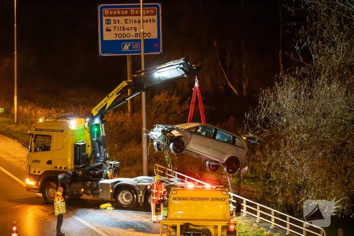 Auto belandt in water naast snelweg