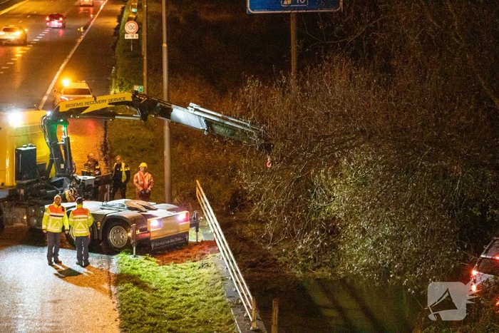 Auto belandt in water naast snelweg
