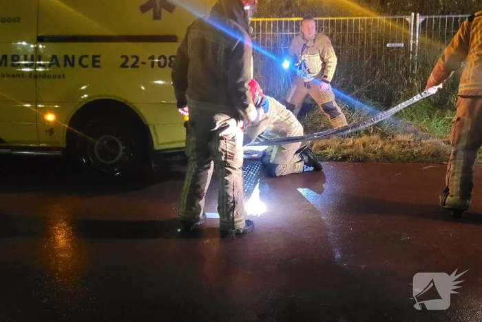 Brandweer trekt ambulance en auto uit modder