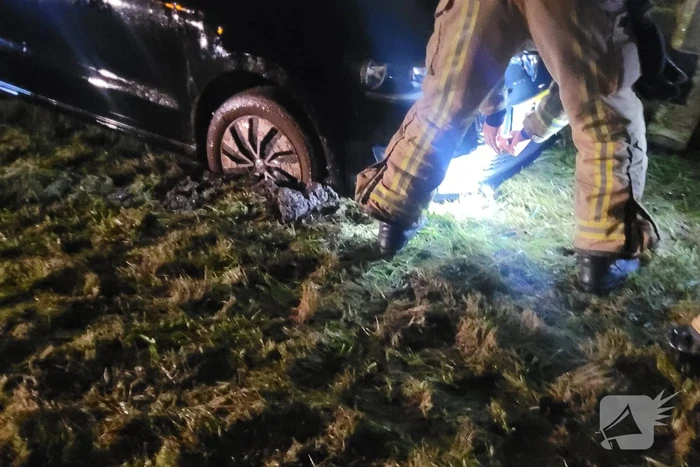 Brandweer trekt ambulance en auto uit modder