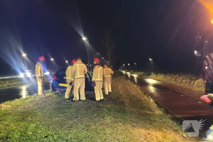 Brandweer trekt ambulance en auto uit modder