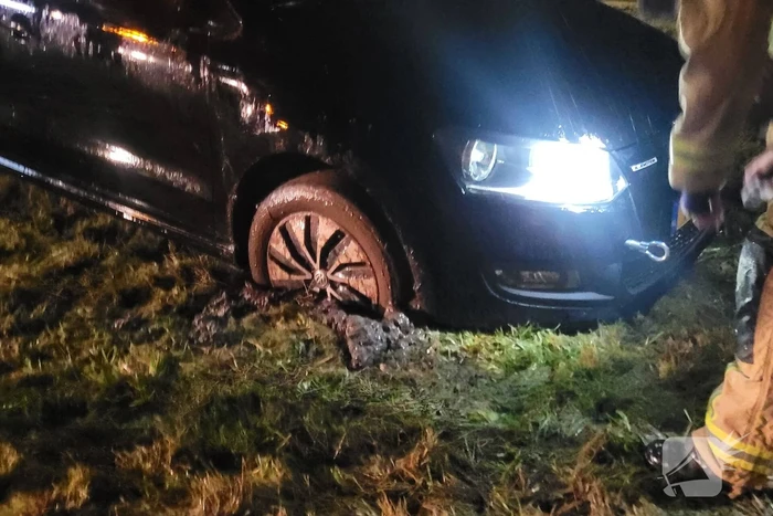 Brandweer trekt ambulance en auto uit modder