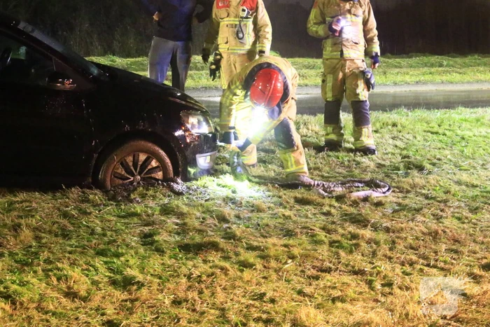Brandweer trekt ambulance en auto uit modder