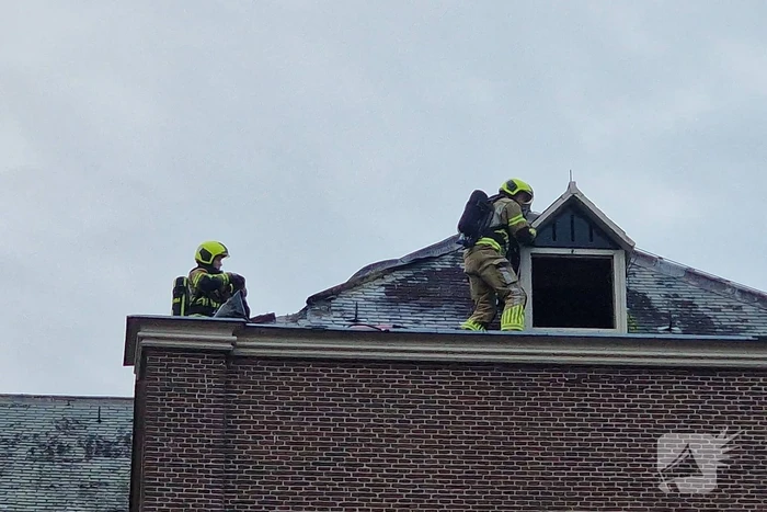 Brandweer blust brand op dak van Kapel