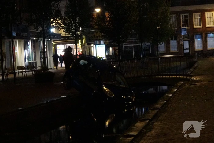 Auto komt in gracht te hangen