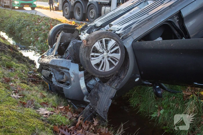 Auto op zijn kop na aanrijding met vrachtwagen