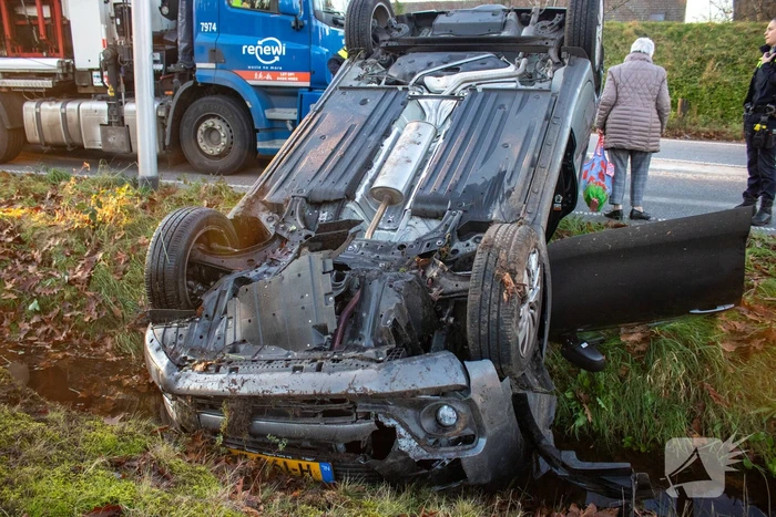 Auto op zijn kop na aanrijding met vrachtwagen