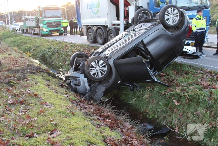Auto op zijn kop na aanrijding met vrachtwagen