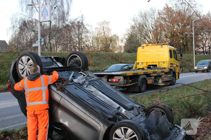 Auto op zijn kop na aanrijding met vrachtwagen
