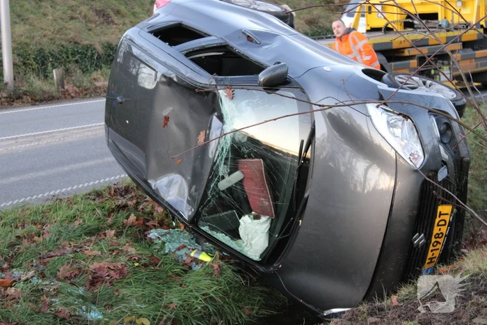 Auto op zijn kop na aanrijding met vrachtwagen