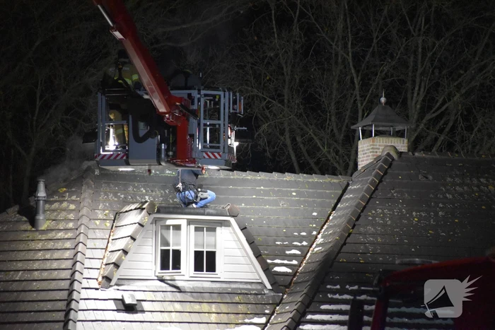 Persoon op dak van woning