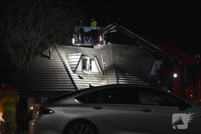 Persoon op dak van woning