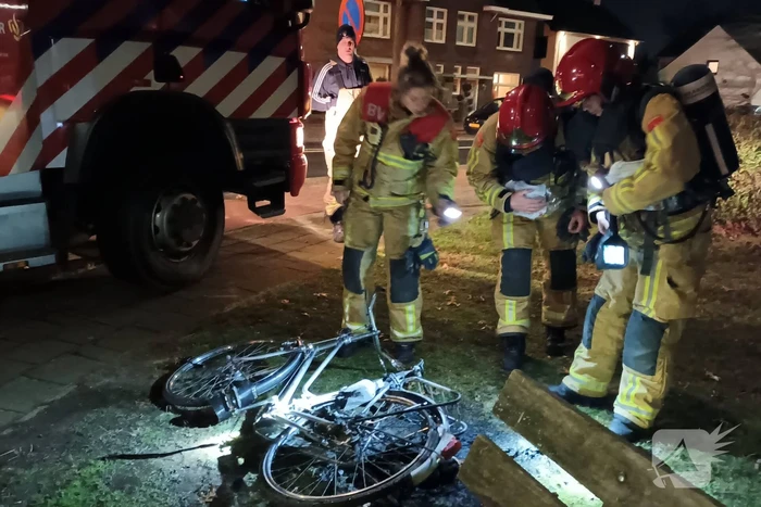 Omstanders blussen brandende fiets