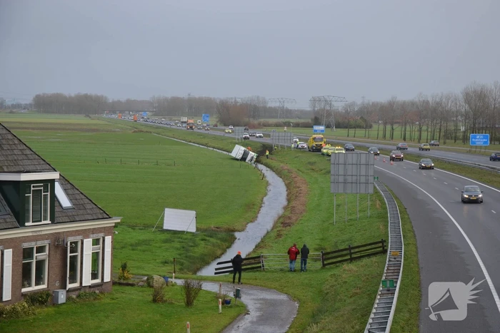 Vrachtwagen gekanteld in sloot naast snelweg