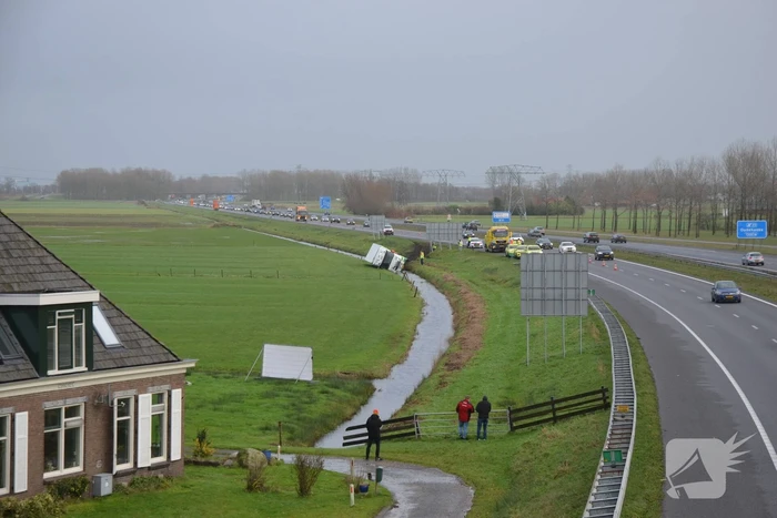 Vrachtwagen gekanteld in sloot naast snelweg