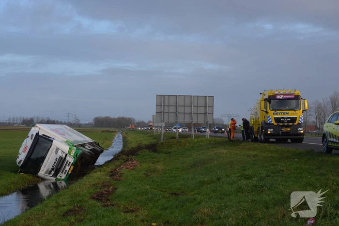 Vrachtwagen gekanteld in sloot naast snelweg