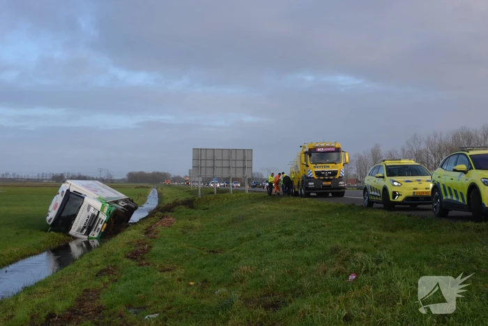 Vrachtwagen gekanteld in sloot naast snelweg