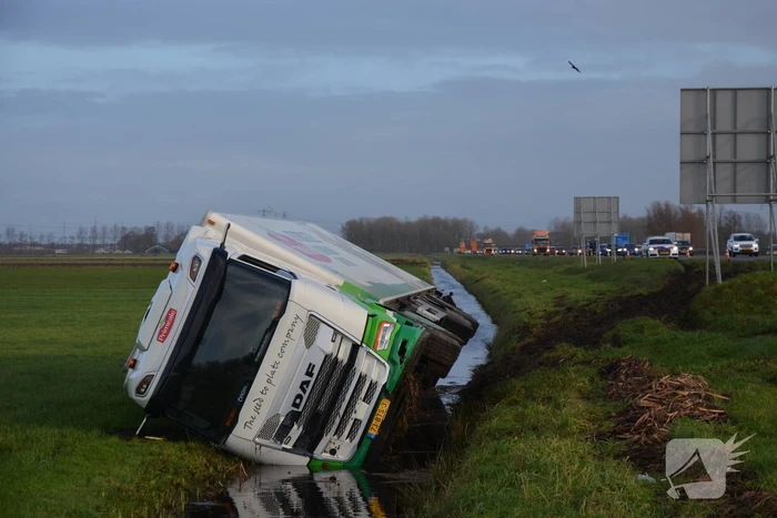 Vrachtwagen gekanteld in sloot naast snelweg