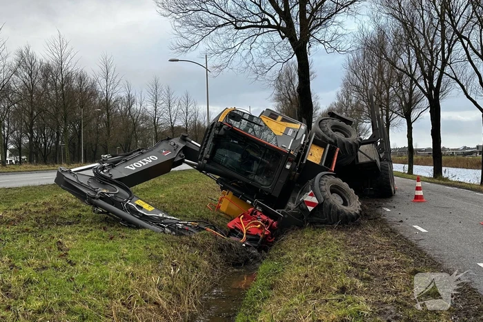 Graafmachine kantelt en komt in sloot terecht