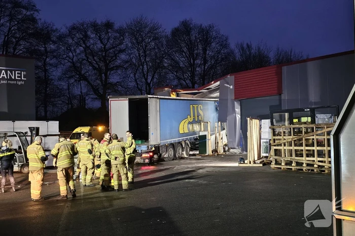 Truck met oplegger rijdt bedrijfspand binnen